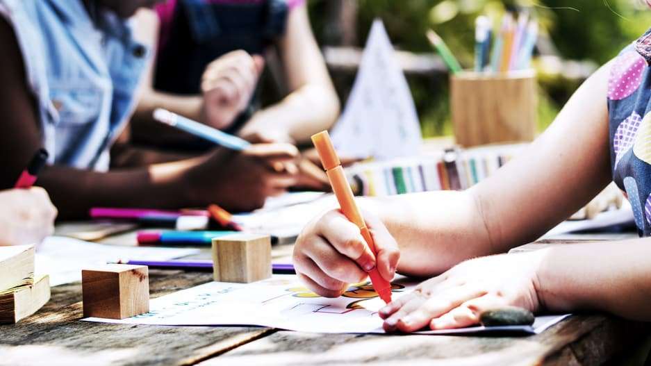 ребенок рисует цветными карандашами
